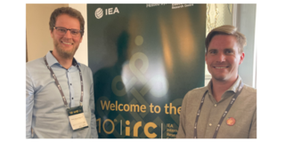 Foto von Ruben Kleinkorres (links) und Ulrich Ludewig (rechts) vor einem Plakat der IRC.