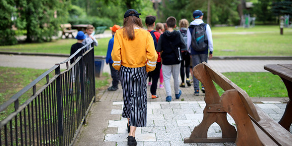 Kinder laufen auf dem Schulhof weg von der Kamera