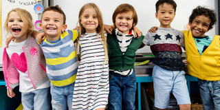 Sechs lächelnde Grundschulkinder