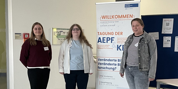 Carina Jüschke, Luisa Mörchen und Alyssa Grecu stehen neben einem Poster der AEPF