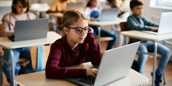 Digitales Klassenzimmer Grundschulkinder arbeiten in ihrem Klassenraum an Laptops