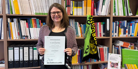 Professur Stang-Rabrig Justine Stang-Rabrig startet als Juniorprofessorin und präsentiert ihre Urkunde.
