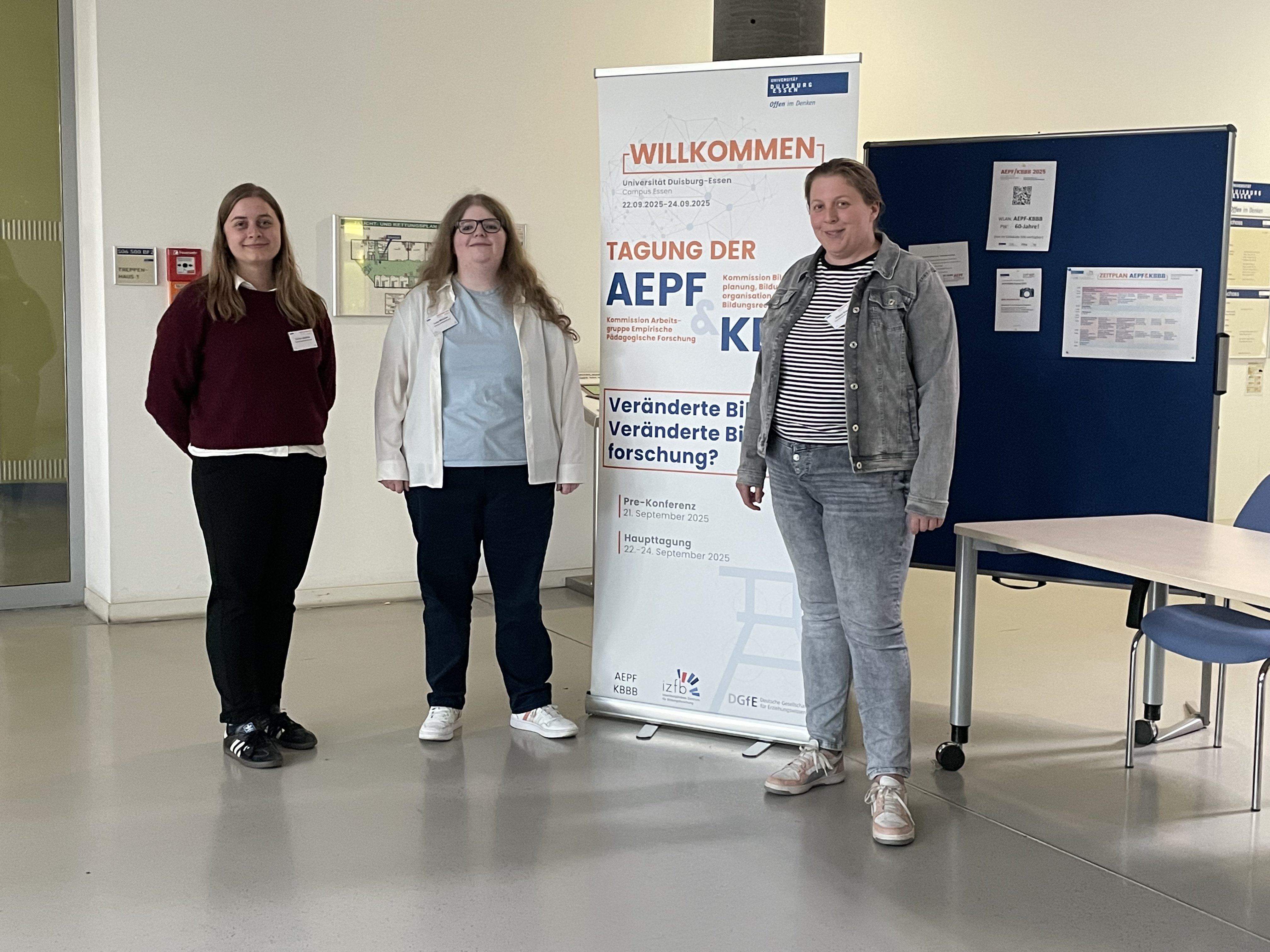 AEPF 2025 Carina Jüschke, Luisa Mörchen und Alyssa Grecu stehen neben einem Poster der AEPF