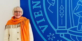 Silvia-Iris Beutel neben dem Logo der Universität Wien